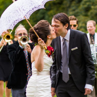 Bride and groom kissing after ceremony at cocktail with jazz band playing hot jazz music
